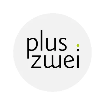 Schwarzer Schriftzug "plus:zwei" auf weißem Kreis, Doppelpunkt mit grünem Punkt.