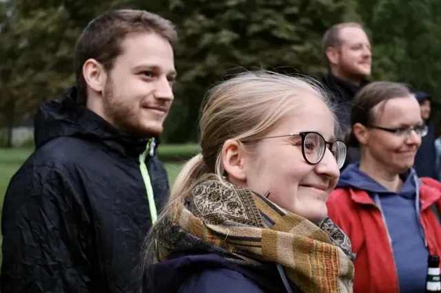 Mehrere Menschen stehen draußen und lächeln.