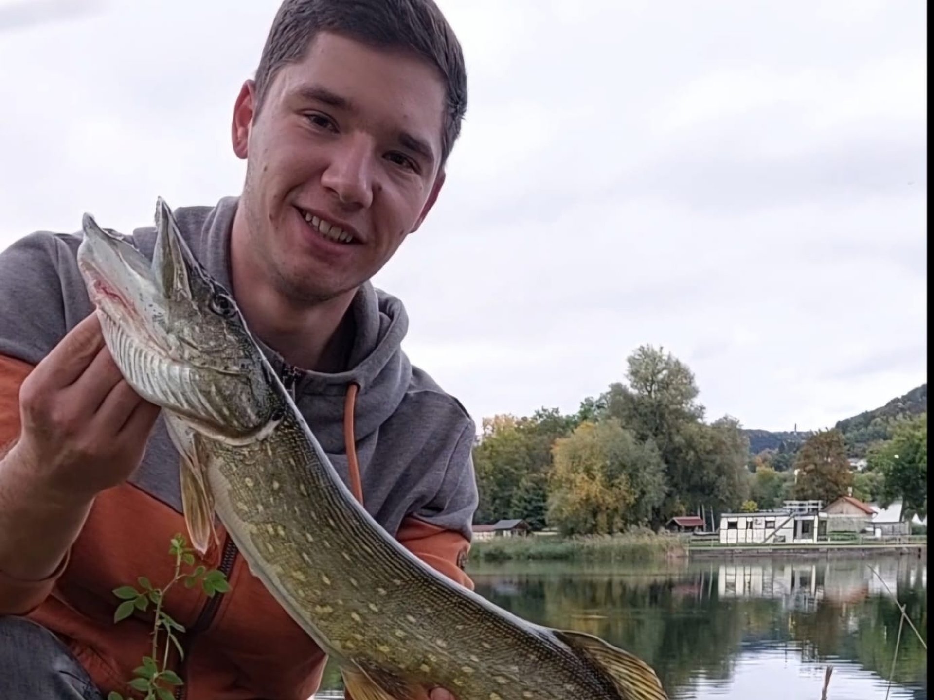 EIn Mann hält einen gefangenen Hecht